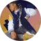 A person with long braided hair is sitting and looking to the side. They are wearing a blue and white varsity jacket, a white shirt, and gray pants. The background features abstract patches of orange, pink, and purple colors.
